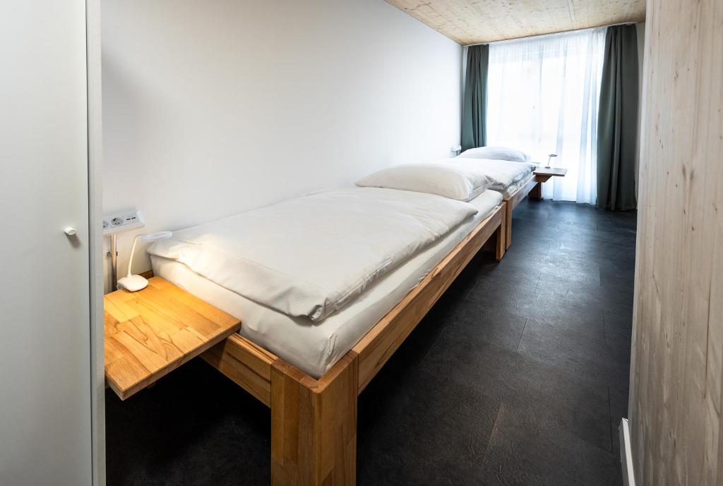 朗道因德普法尔茨Boardinghouse-Landau的一间卧室设有两张床和一张木桌