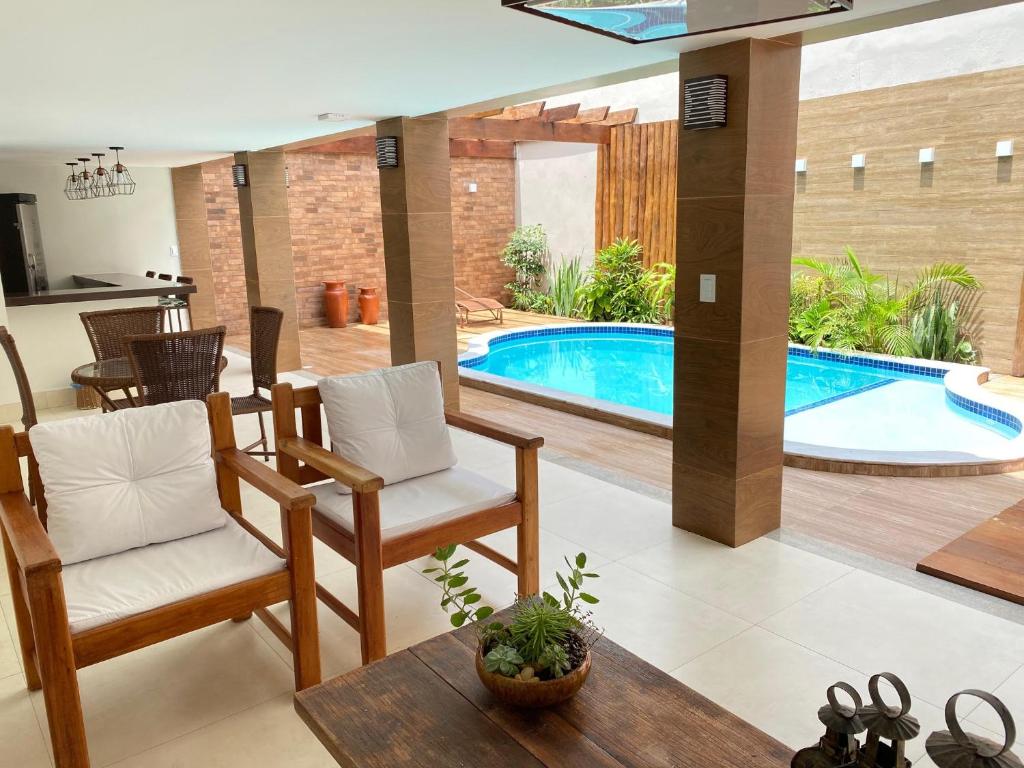 塞古罗港Hotel Portal do Descobrimento的客厅设有游泳池、椅子和桌子