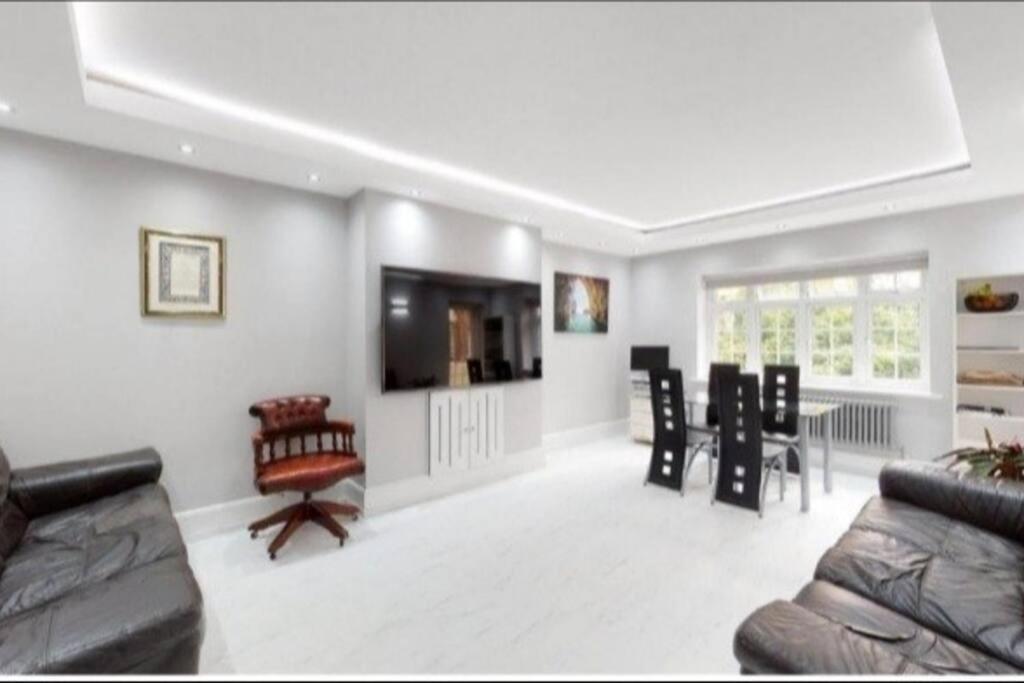 伦敦9 Brentwood Lodge的客厅配有沙发和桌椅