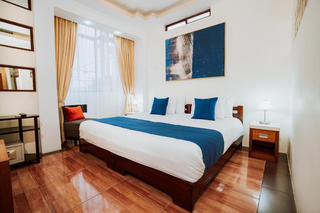 阿约拉港帕丽斯加拉帕戈斯酒店的一间卧室配有一张带蓝白色床单的大床