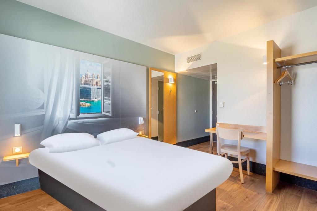 马赛B&B HOTEL Marseille Euromed的卧室配有一张白色的大床和一张桌子