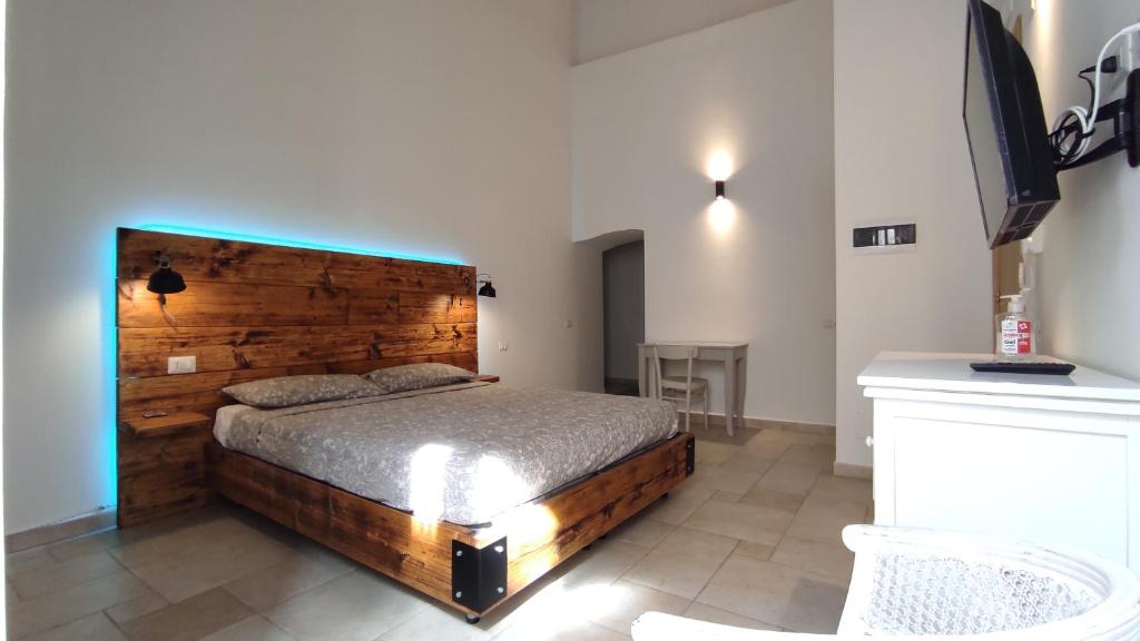 科拉托B&B Santa Rita Corato的一间卧室配有一张带木制床头板的床