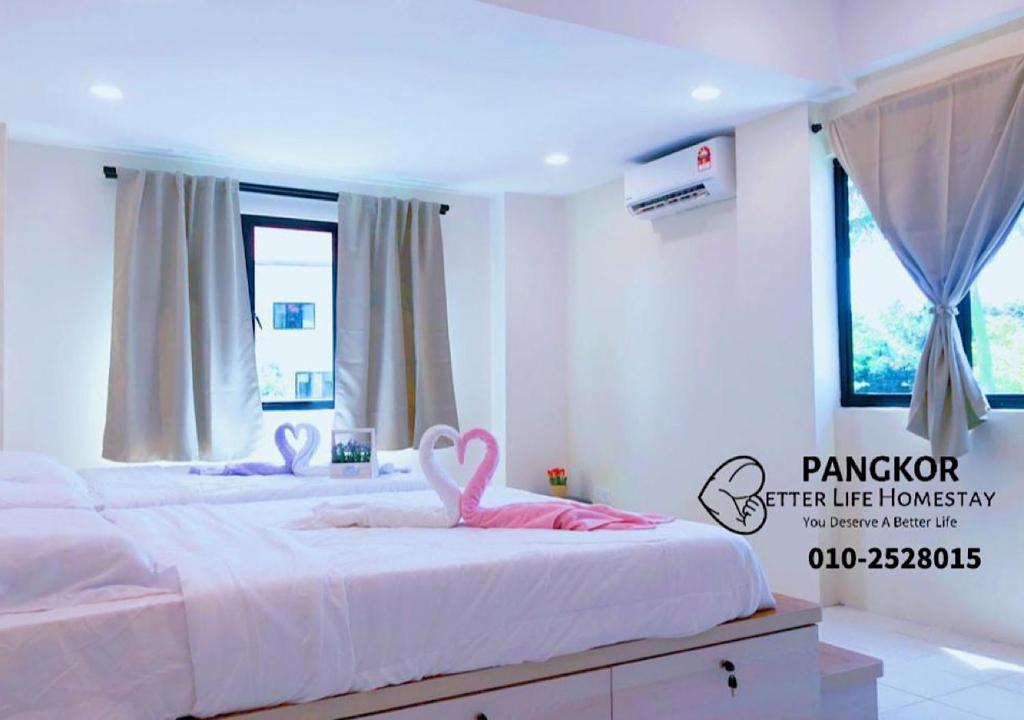 邦咯Pangkor Pasir Bogak Apartment 2Rooms 2Bathrooms near beach 6pax FREE WIFI的卧室内的两张床和粉红色天鹅