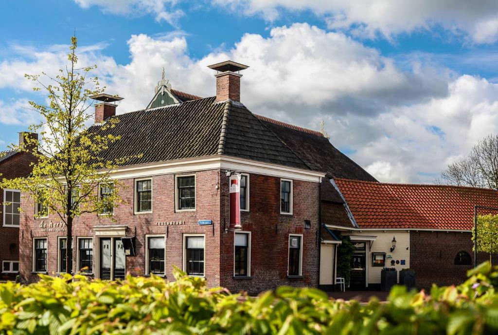 RottevalleTeades Plak bij De Herberg van Smallingerland的一座大型红砖房,屋顶