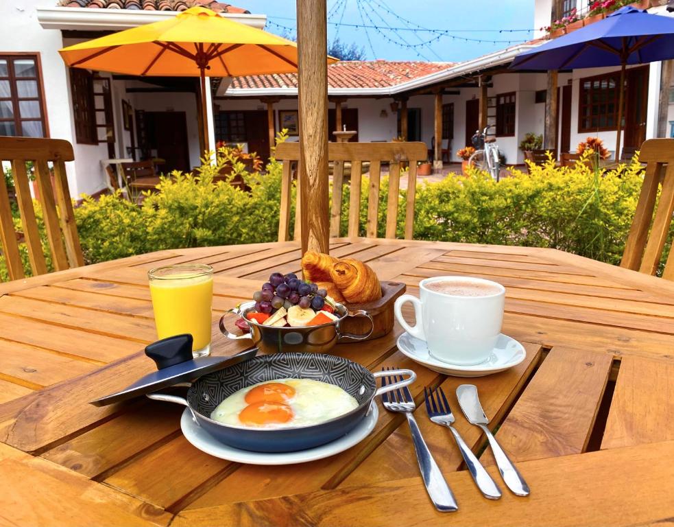 莱瓦镇Hotel Evoque Sáchica的木桌旁的早餐包括鸡蛋和咖啡