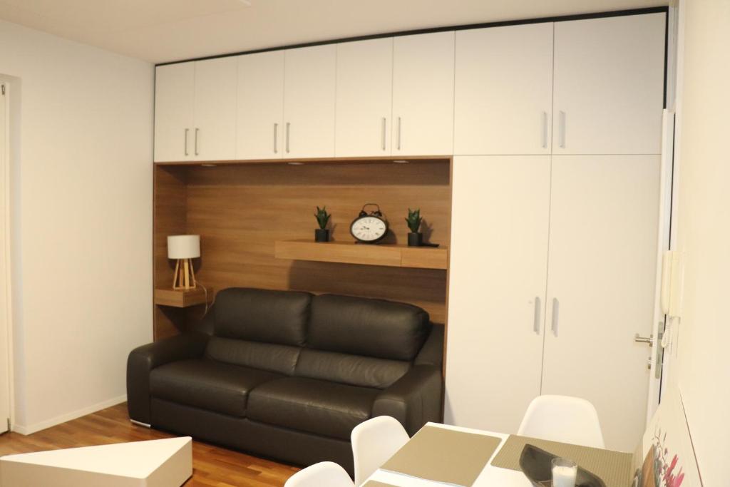 普图伊Studio apartma Terme Ptuj的客厅配有黑色真皮沙发和白色橱柜