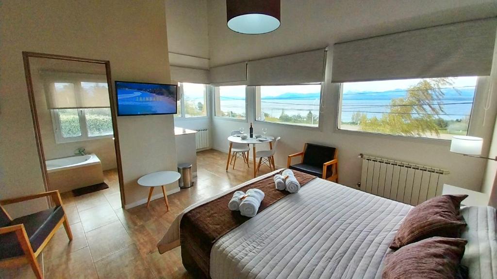 圣卡洛斯-德巴里洛切Las Victorias Suites Bariloche的一间卧室配有一张大床和电视