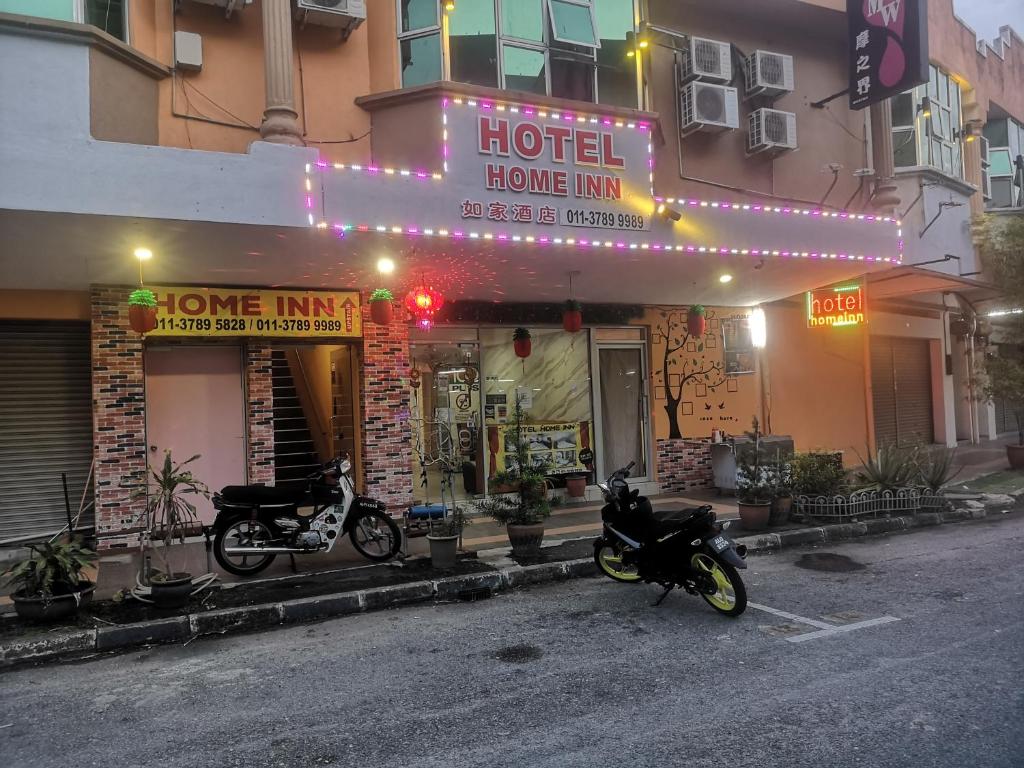 怡保Home Inn Hotel的一辆停在前面的摩托车