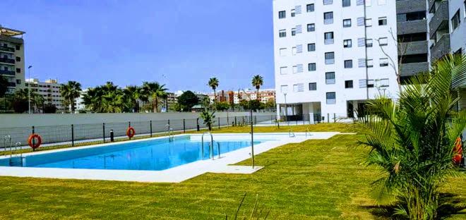 马拉加Ático con Piscina y Vistas al Mar Parque Litoral的一座大建筑前的游泳池