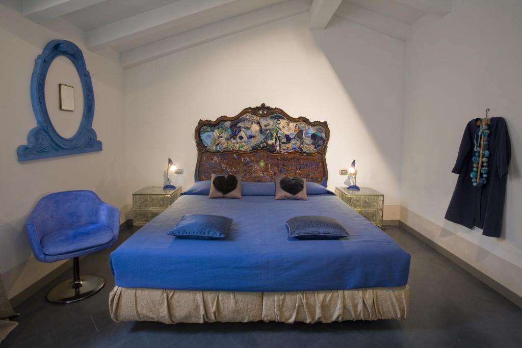 帕多瓦阿尔法贾诺艺术酒店的一间卧室配有蓝色的床和蓝色椅子