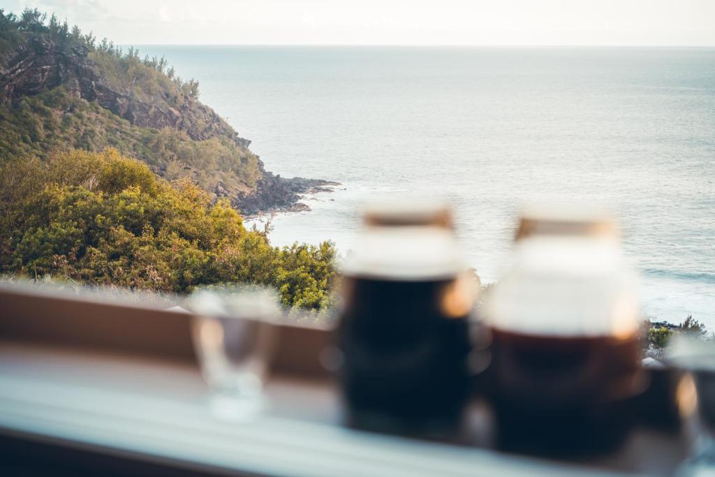 珀蒂蒂勒Le Coin d'Azur的两瓶啤酒坐在俯瞰大海的阳台上