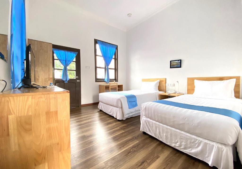 格劳Hinode Hotel ဟိနောဒေ့ဟိုတယ်的酒店客房设有两张床和一台平面电视。