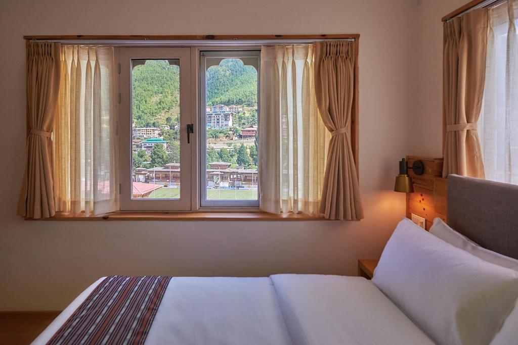廷布The Willows Hotel, Bhutan的一间卧室设有一张床和一个大窗户