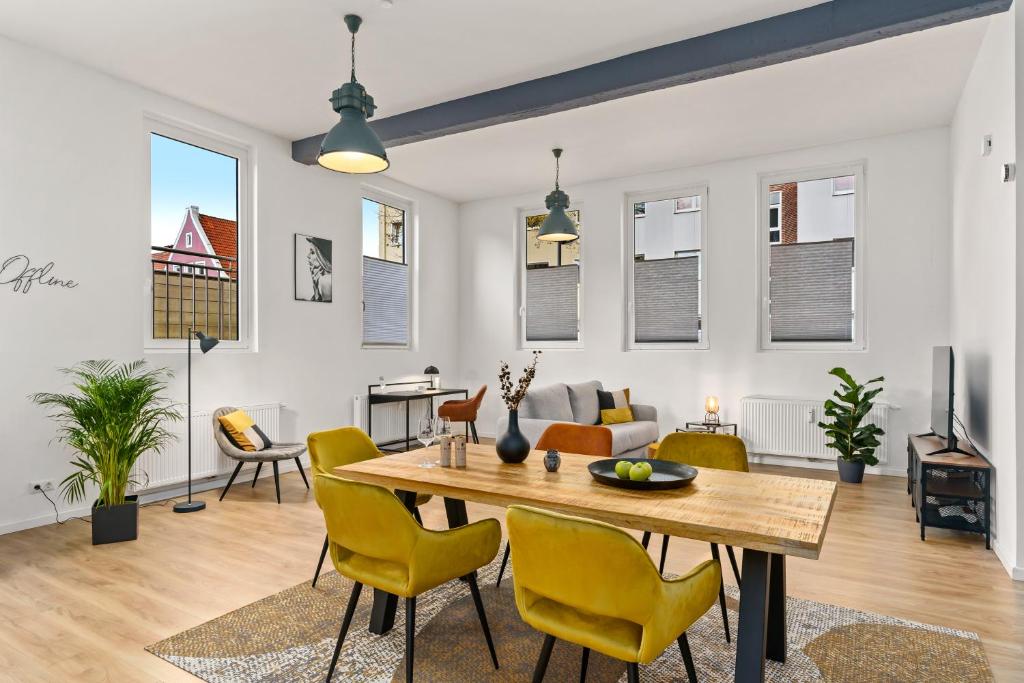 不莱梅Loft-Appartements mit Terrasse的客厅配有木桌和黄色椅子