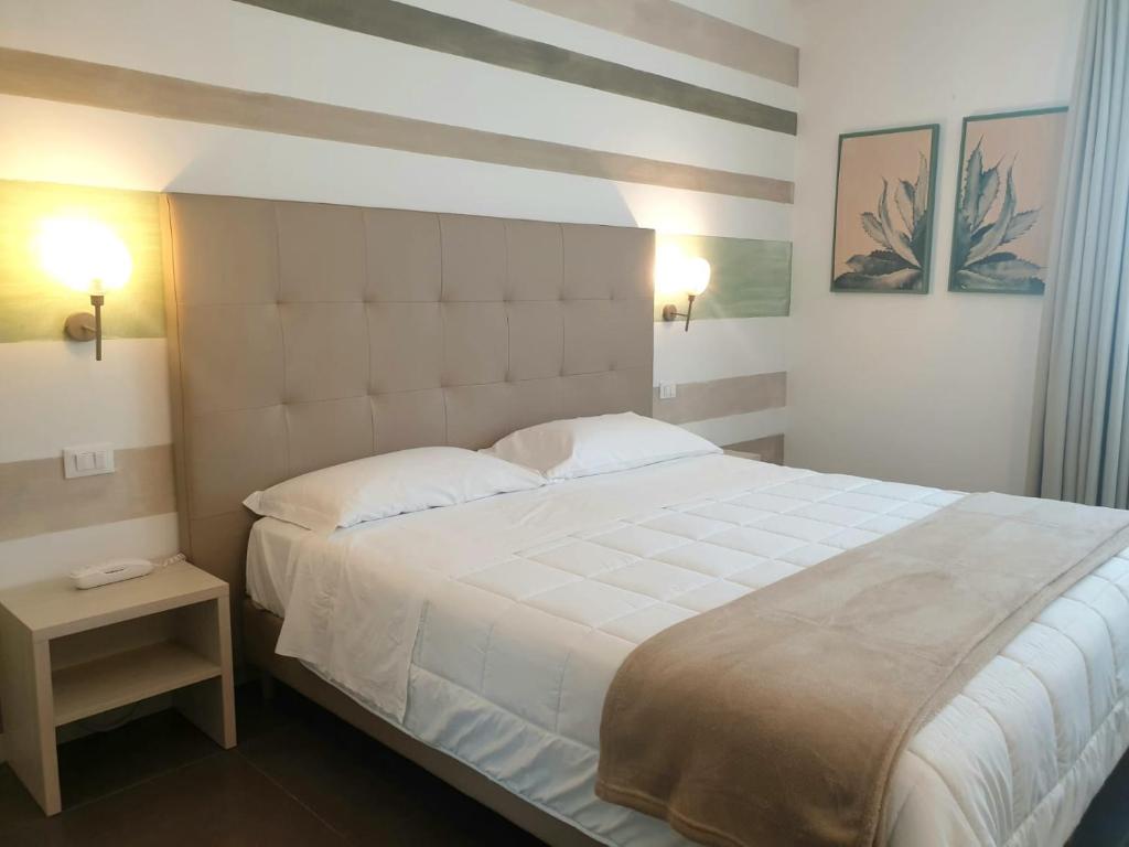 基亚拉蒙泰-古尔菲Hotel Grel的卧室配有一张带两个枕头的大白色床