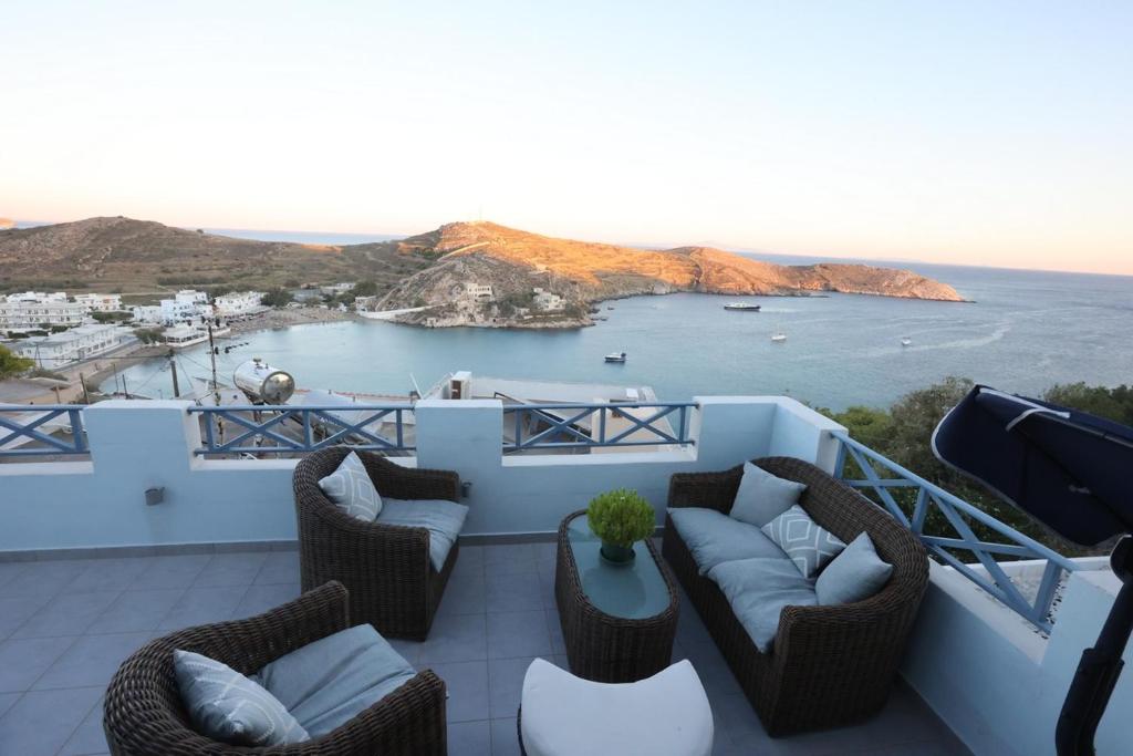 瓦里Vacation house with stunning view - Vari Syros的阳台配有桌椅,享有海景。