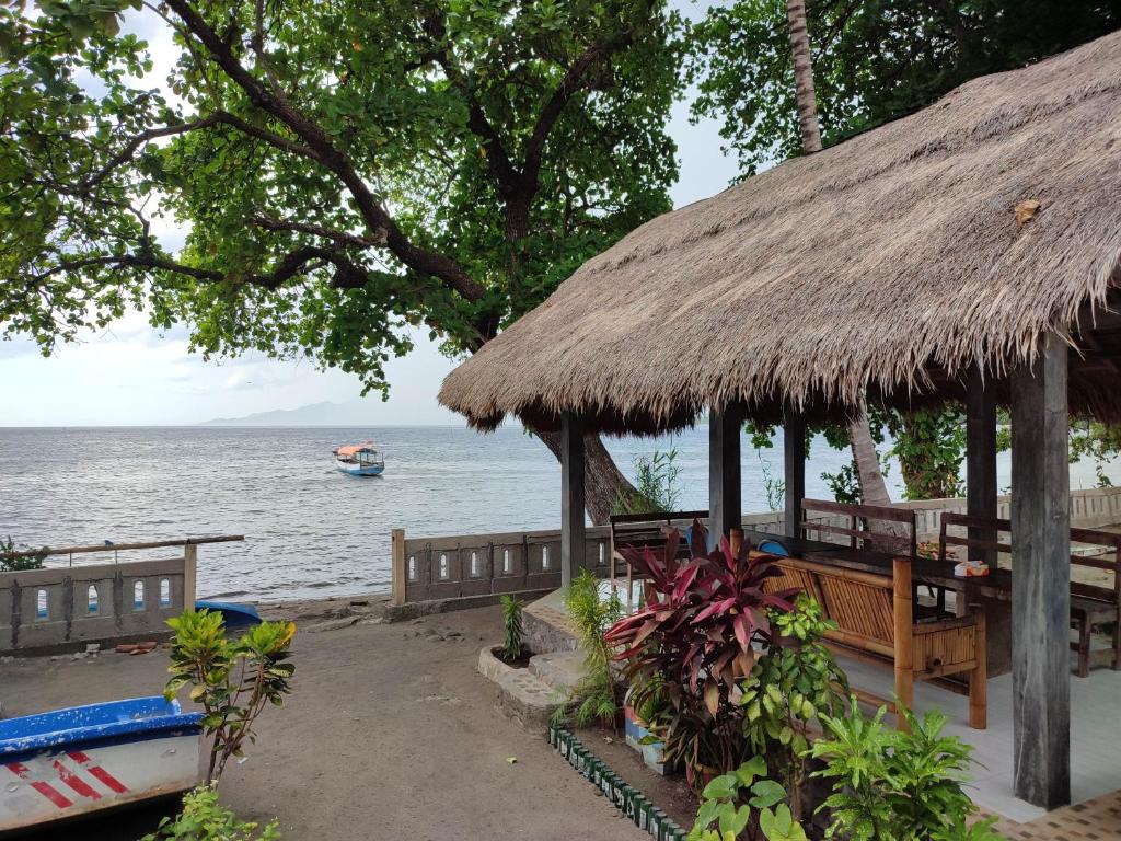 HitokalakLena house Flores的水中带长凳和船只的小屋