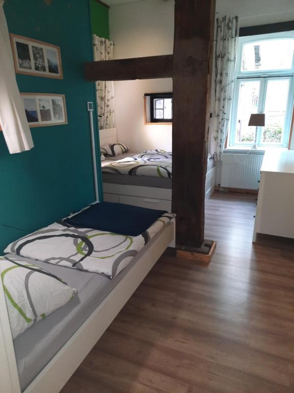 BülstedtFerienwohnung Noltenius的配有绿色墙壁和木地板的客房内的两张床
