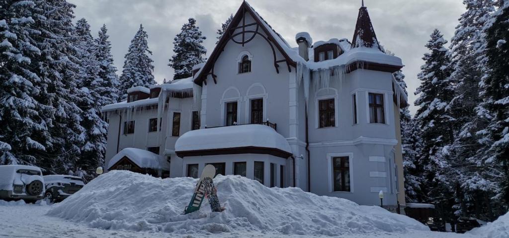 波罗维茨巴尔别墅酒店的雪板在雪覆盖的房子前