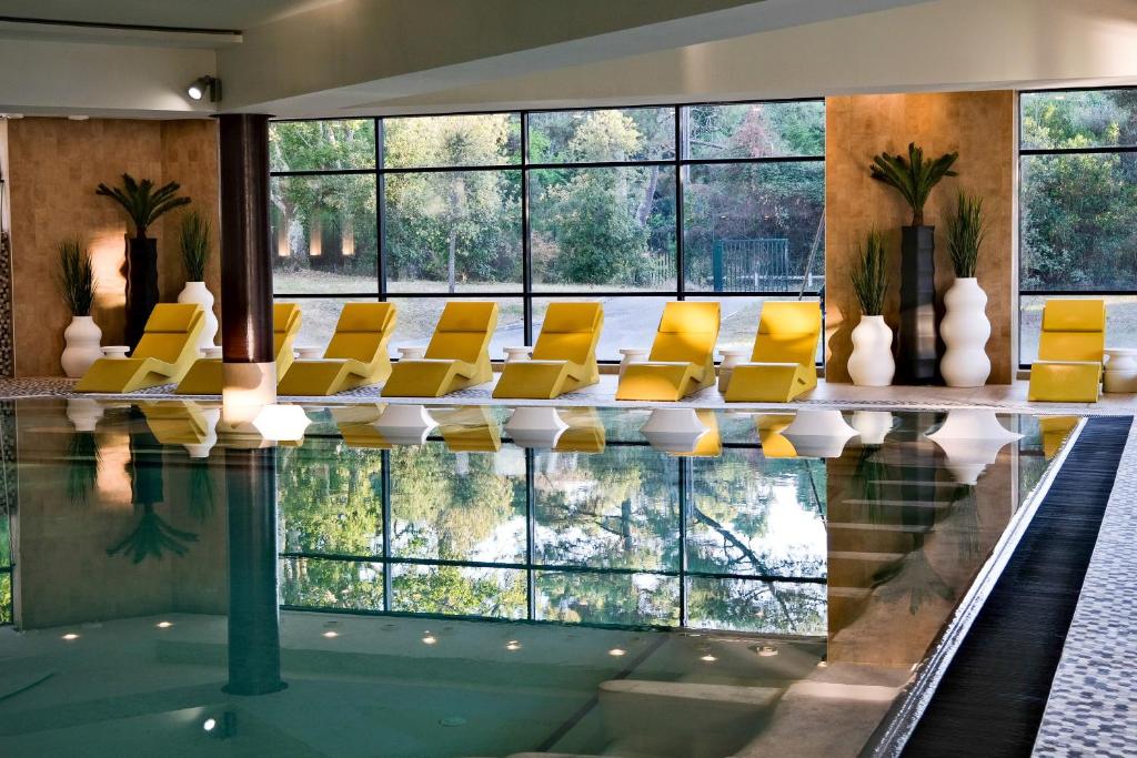 阿卡雄Thalazur Arcachon - Hôtel & Spa的一座带黄色椅子的游泳池