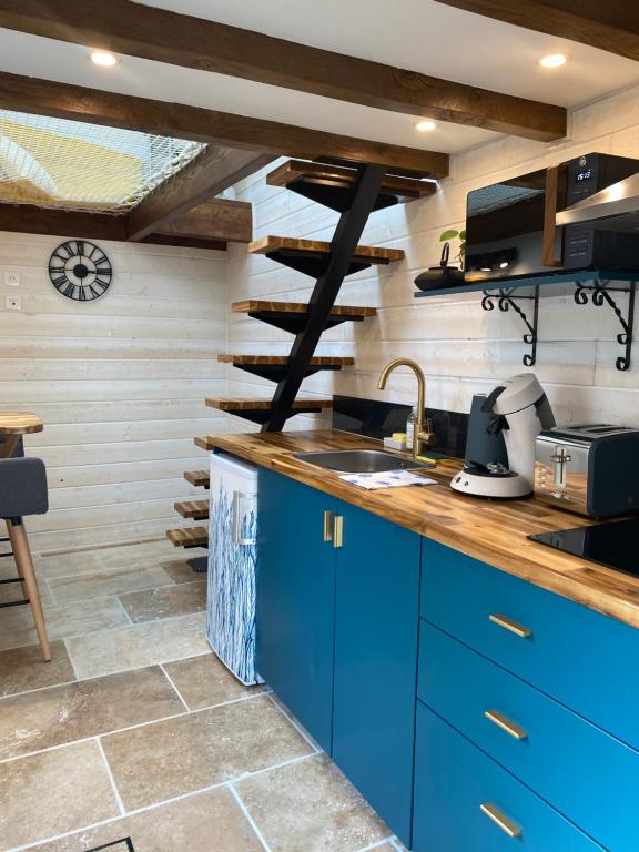圣艾尼昂La Tiny Blue - maison insolite pour 2 - sans Tv的厨房配有蓝色橱柜和水槽