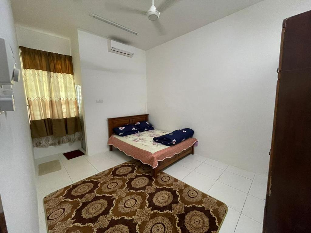 双溪大年Basic Homestay For Big Family With Wifi 100mpbs的小房间,配有床和地毯