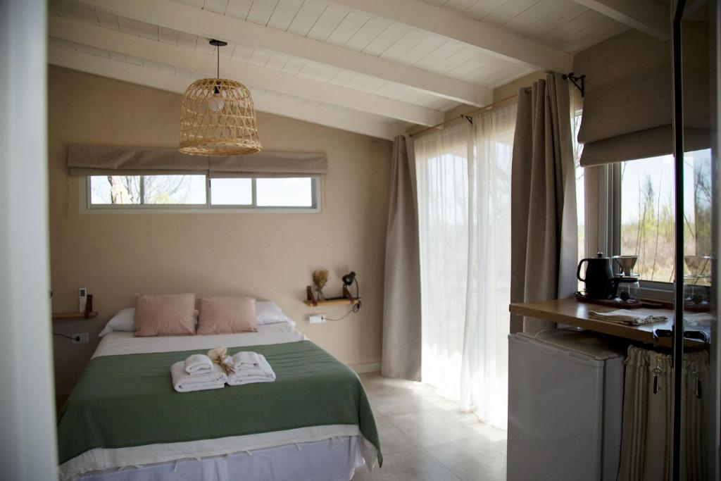 诺诺Las Quimeras的一间卧室配有带毛巾的床