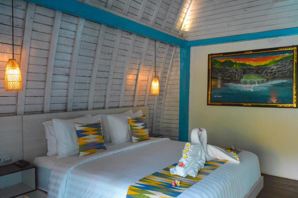 珀尼达岛The MG Villa & SPA的一间卧室配有一张带两个天鹅的床