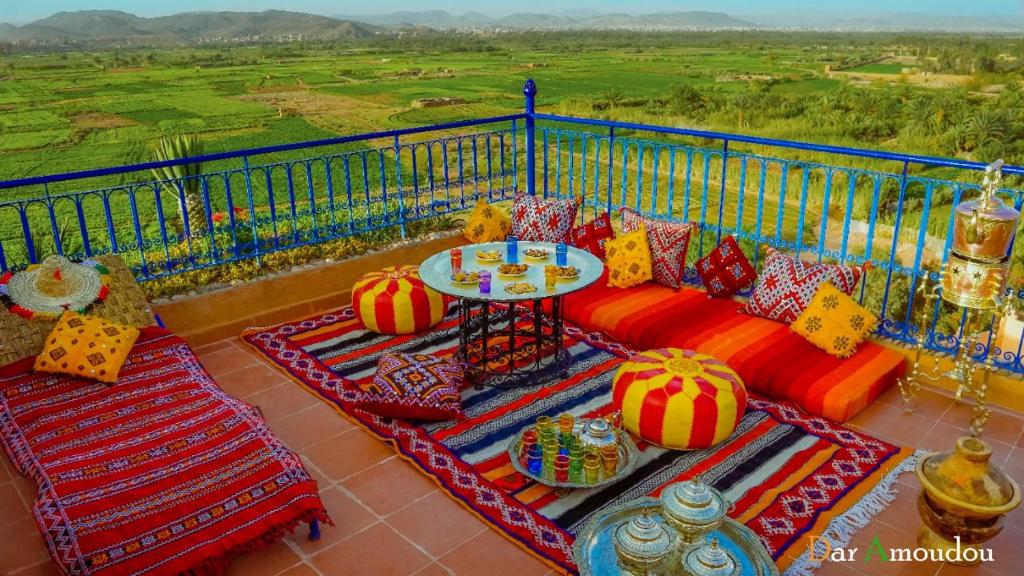 瓦尔扎扎特达尔阿莫多旅馆的阳台配有沙发和带彩色枕头的桌子。
