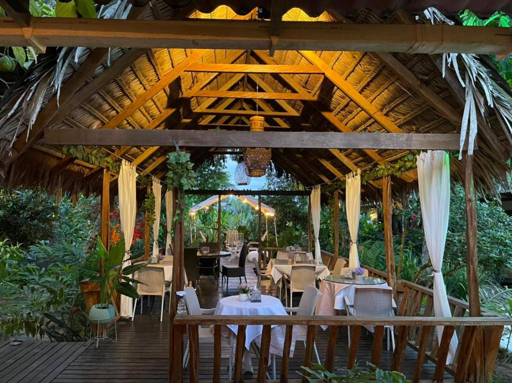 莱蒂西亚Hotel Madreselva的木甲板上设有桌椅的餐厅