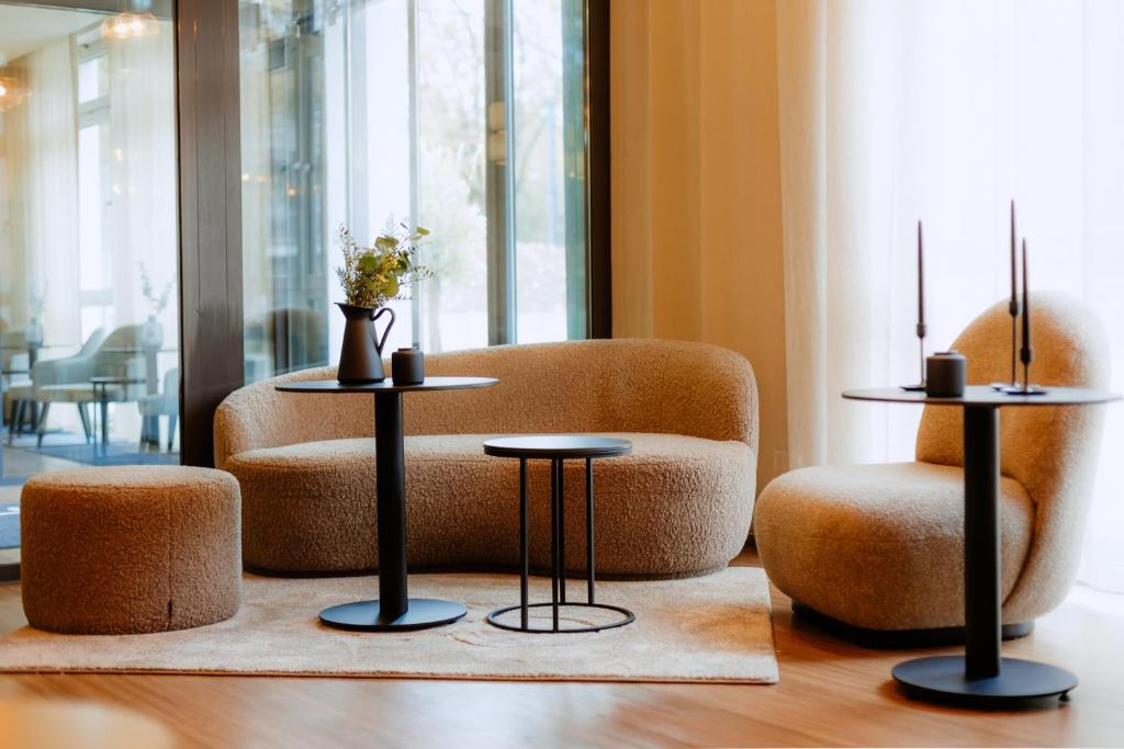 多特蒙德Moods Hotel Dortmund的客厅配有2张桌子和椅子
