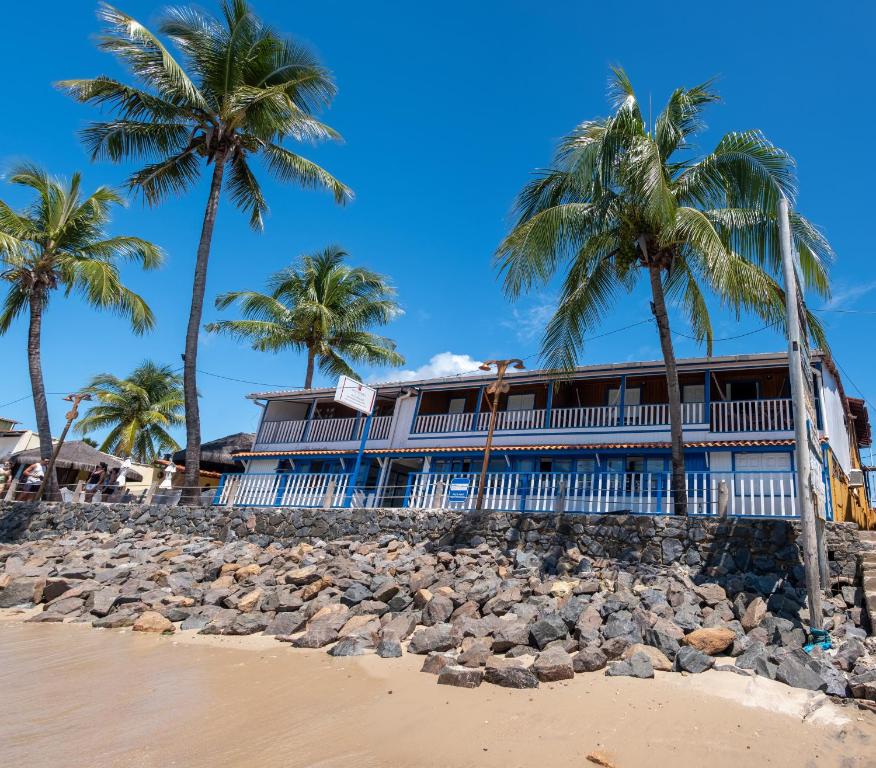 莫罗圣保罗Amendoeira Praia Hotel的棕榈树海滩上的一座建筑