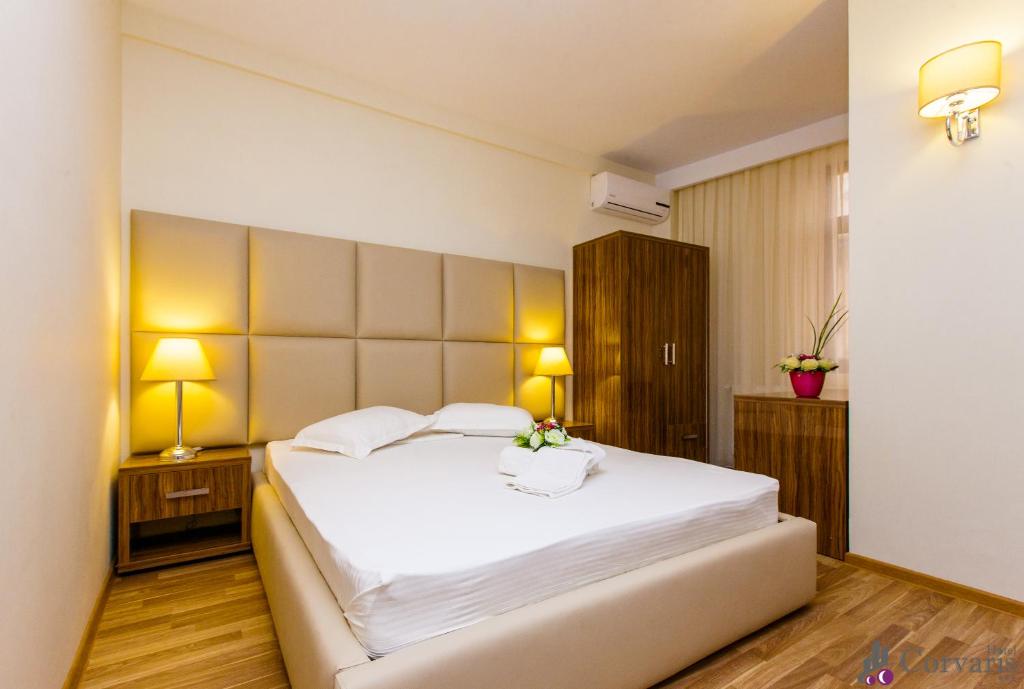 布加勒斯特科维沃斯酒店的卧室配有一张白色大床和两盏灯。