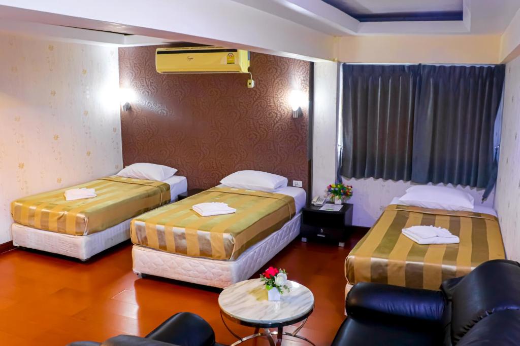 曼谷Visiting Card Hotel & Resort的酒店客房,配有两张床和椅子