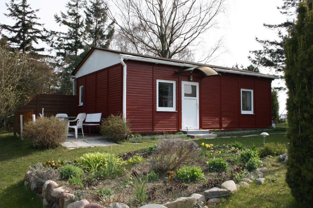 Neu MukranRuegen_Fewo 285的一座红色的小房子,前面有一个花园