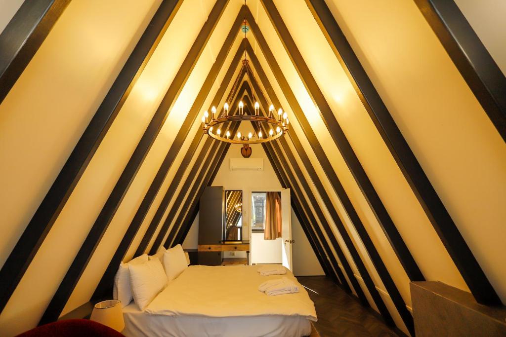 萨潘贾World DREAMS Forest的一间卧室配有两张床和吊灯。