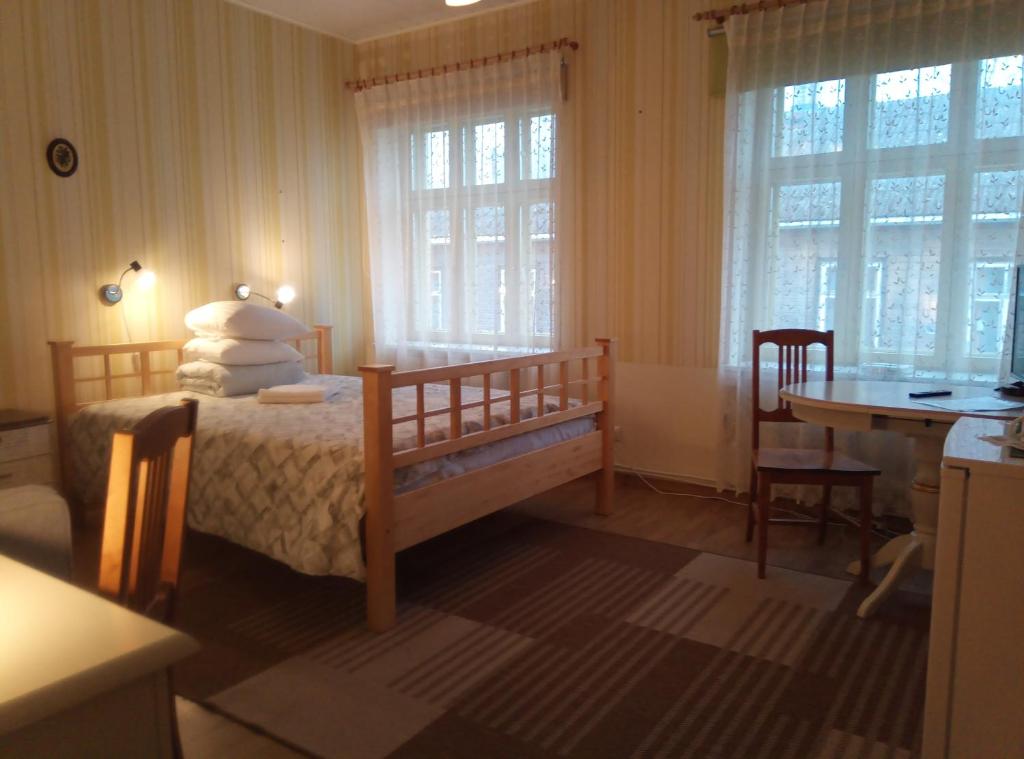 维尔扬迪Tähe Maja1的卧室配有一张床、一张书桌和窗户。