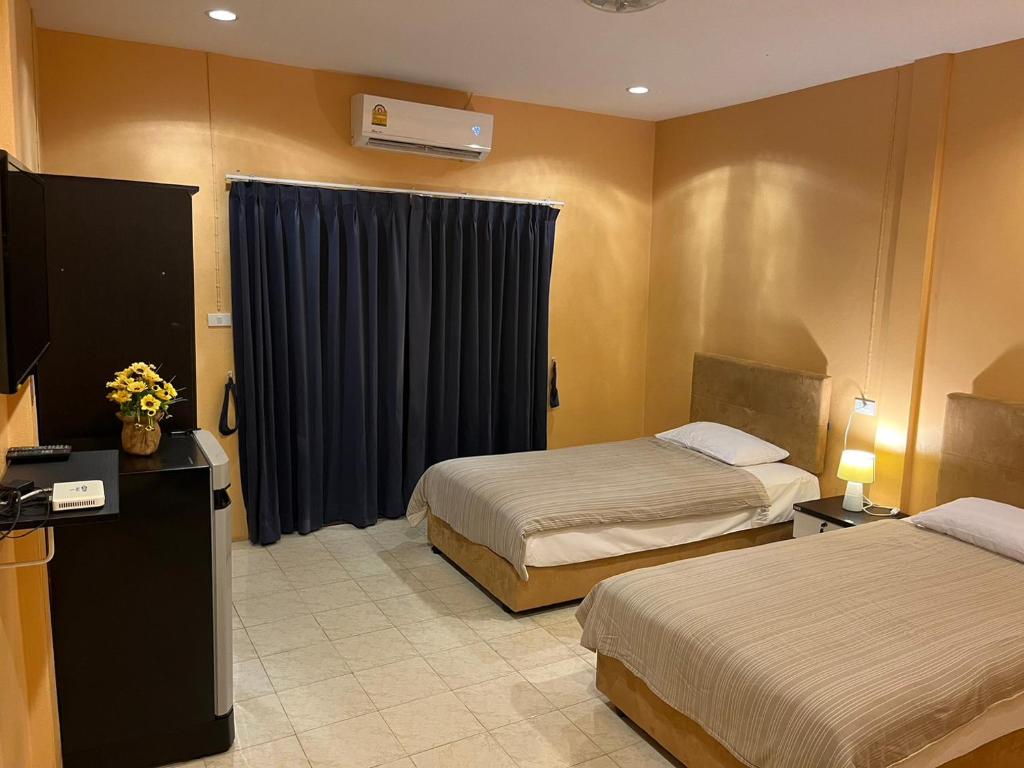 蔻立Khaolak inn的酒店客房设有两张床和电视。