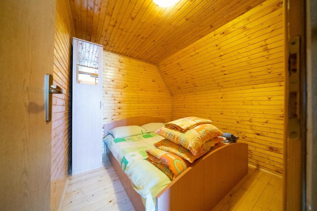 扎布利亚克Apartment Dobre Vode的木制客房内的一间卧室,配有一张床