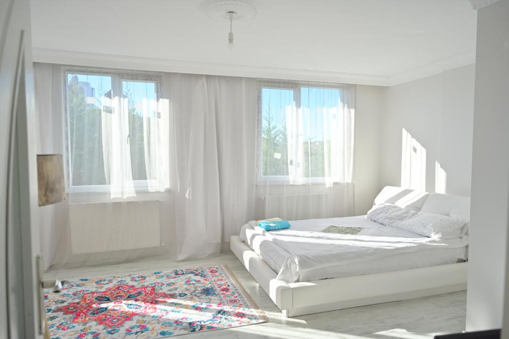 ArnavutköyAhmet teacher's villa, 6 minutes from the airport的一间白色卧室,配有两张床和地毯