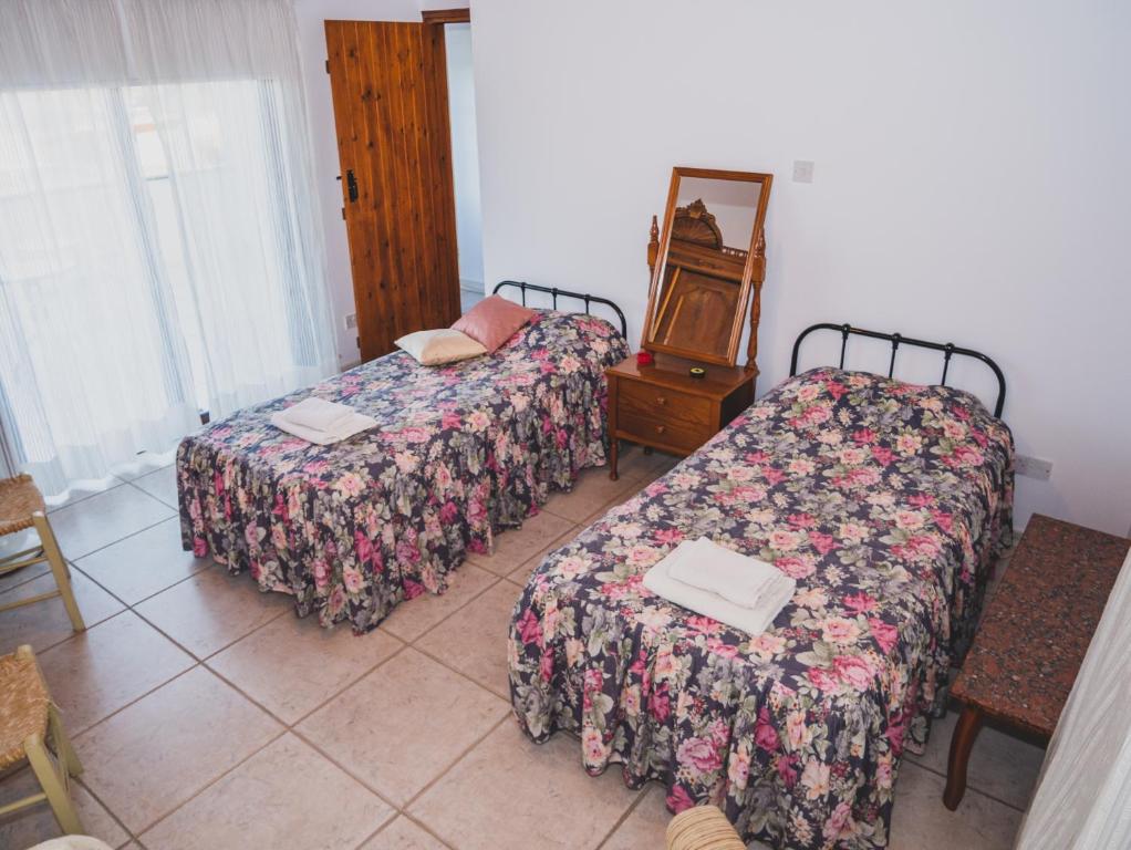 Ayios MamasRevecca House的客房设有两张床、一张桌子和镜子