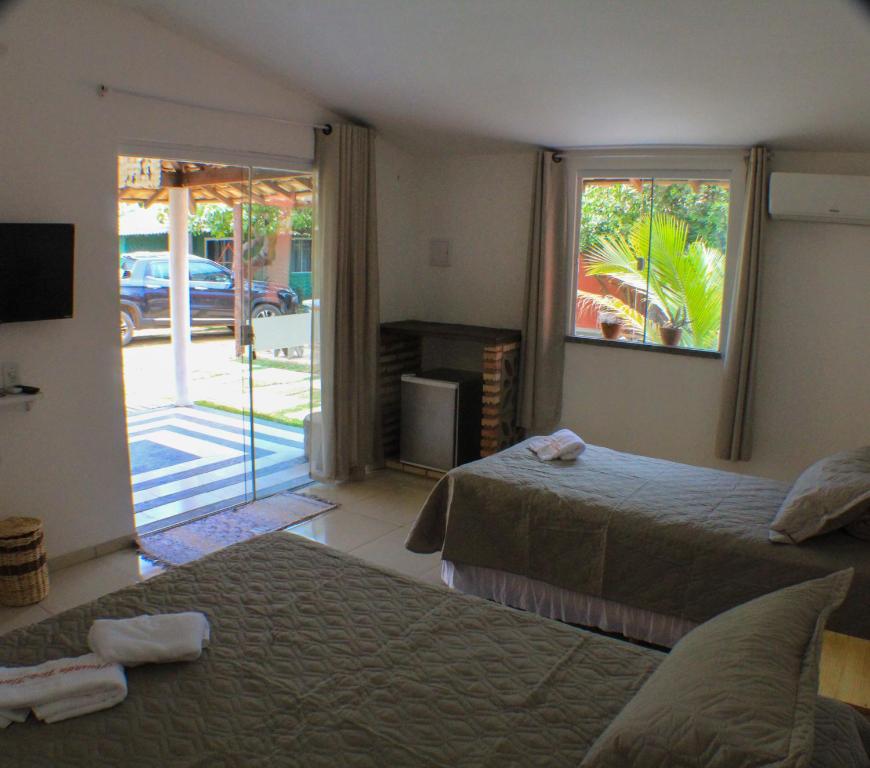 巴拉格兰德Pousada Viva Barra的一间卧室设有两张床和滑动玻璃门