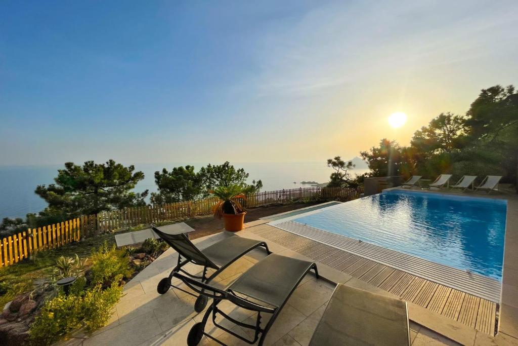 圣拉斐尔Family villa with magnificent sea view for 11 people的一座房子,设有游泳池和甲板上的椅子