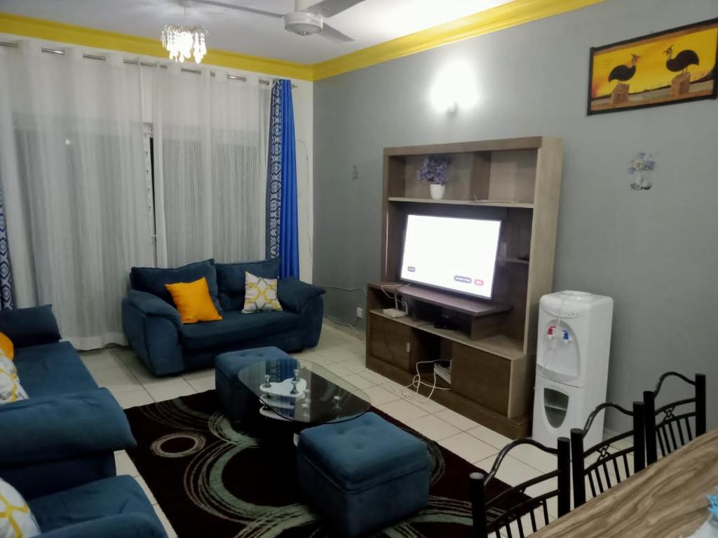 蒙巴萨Mtwapa HomeStay 3br Apartments的客厅配有蓝色的沙发和电视