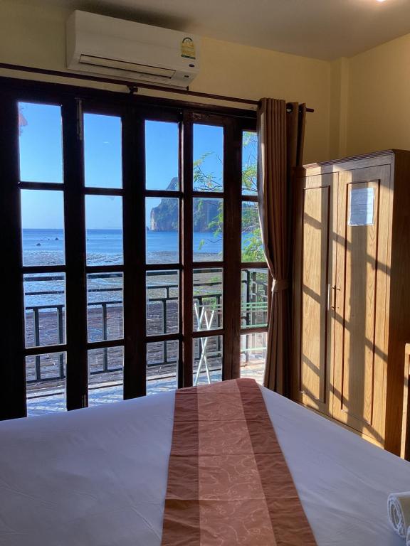 皮皮岛Phi Phi Green House & Sunsky Hostel的一间卧室配有一张床,享有海景