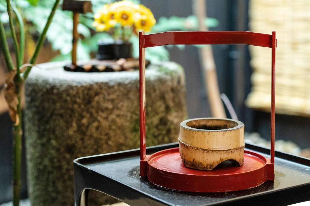 京都ゲストハウス至の宿 Shibainu-Themed Guesthouse的红柱桌上的木杯