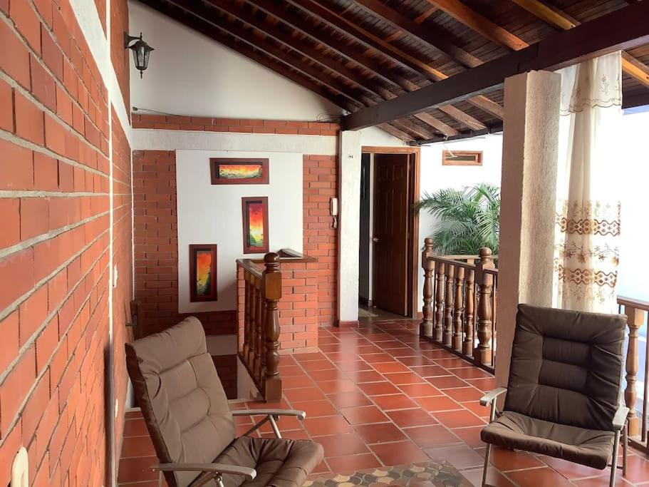 圣希尔San Gil beautiful house的门廊配有两把椅子和砖墙