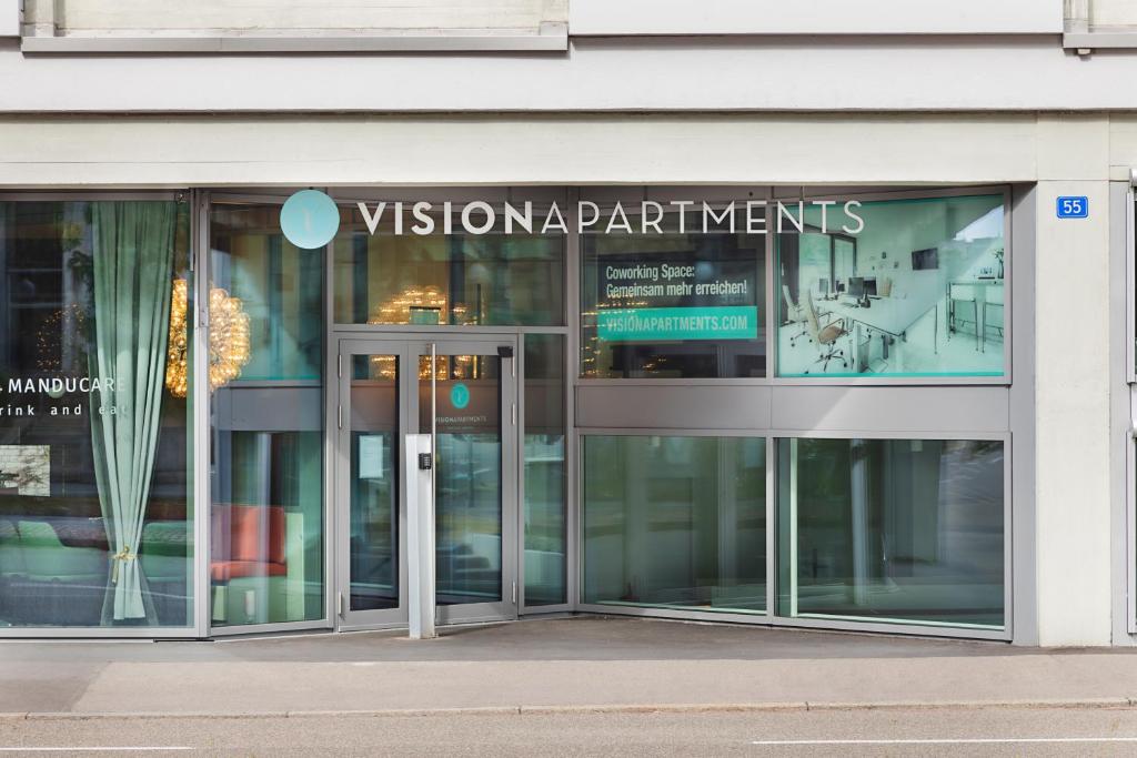 巴塞尔VISIONAPARTMENTS Basel Nauenstrasse - contactless check-in的带有读视图部门的标志的玻璃建筑