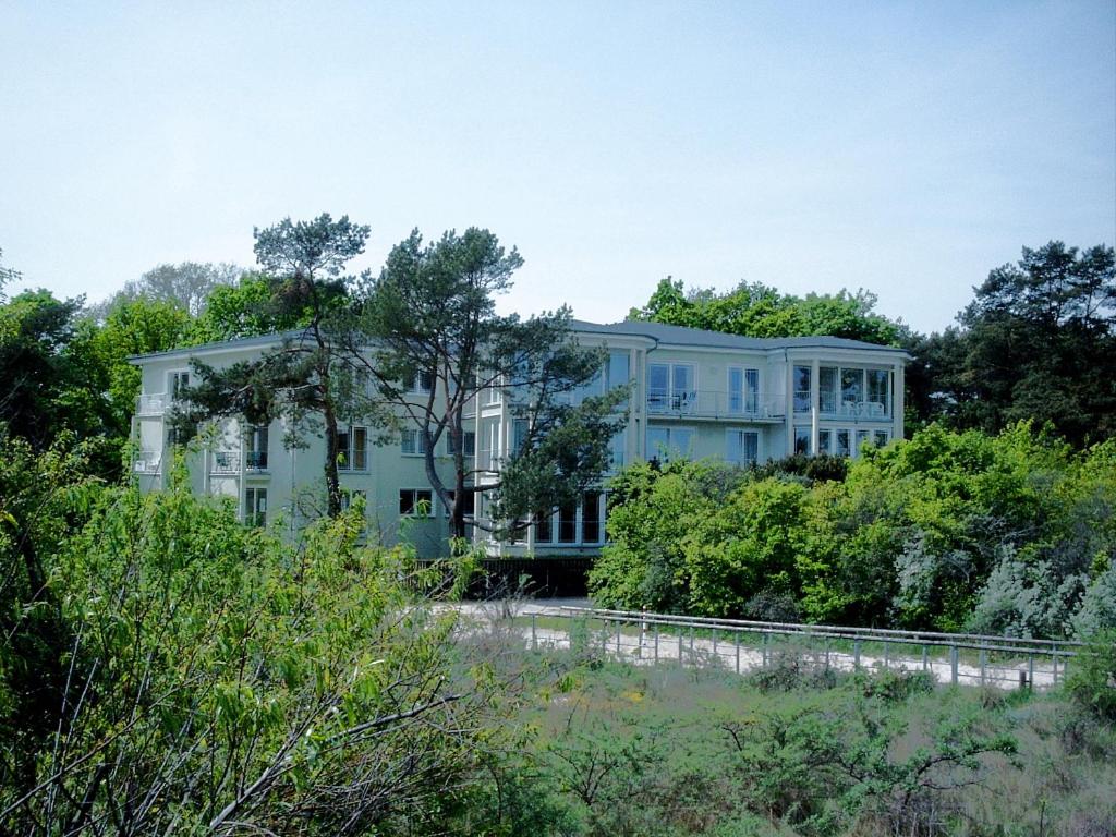 黑灵斯多夫Strandoase-App-04的一座大型蓝色建筑,前面有树木