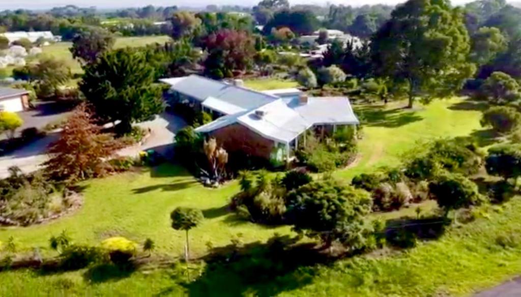 梅尔顿Melbourne Garden Bed and Breakfast的绿色田野上房屋的空中景观